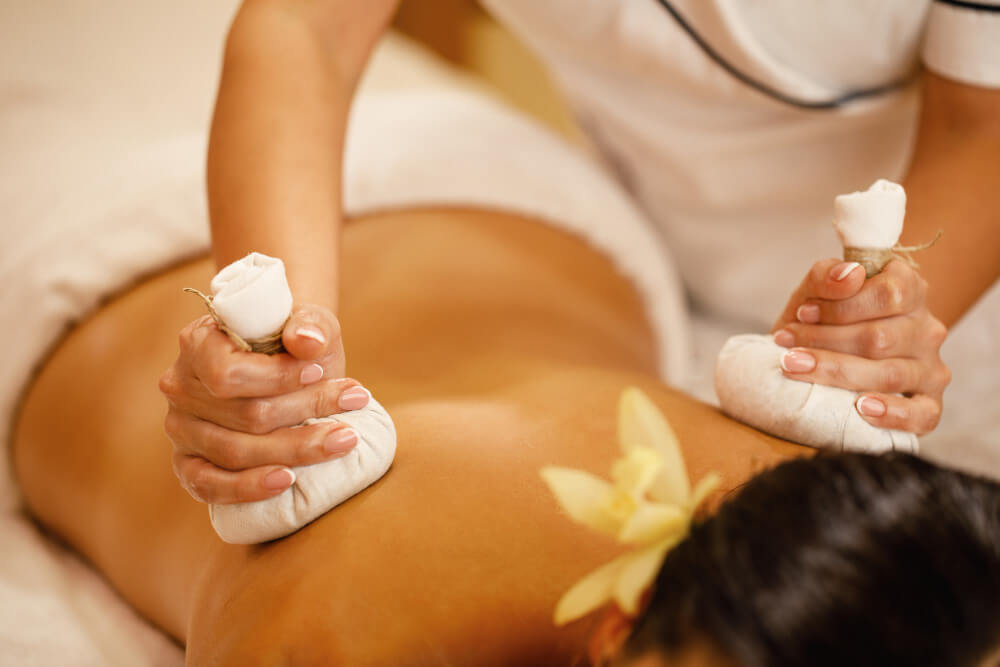Womann getting an herbal compress massage
